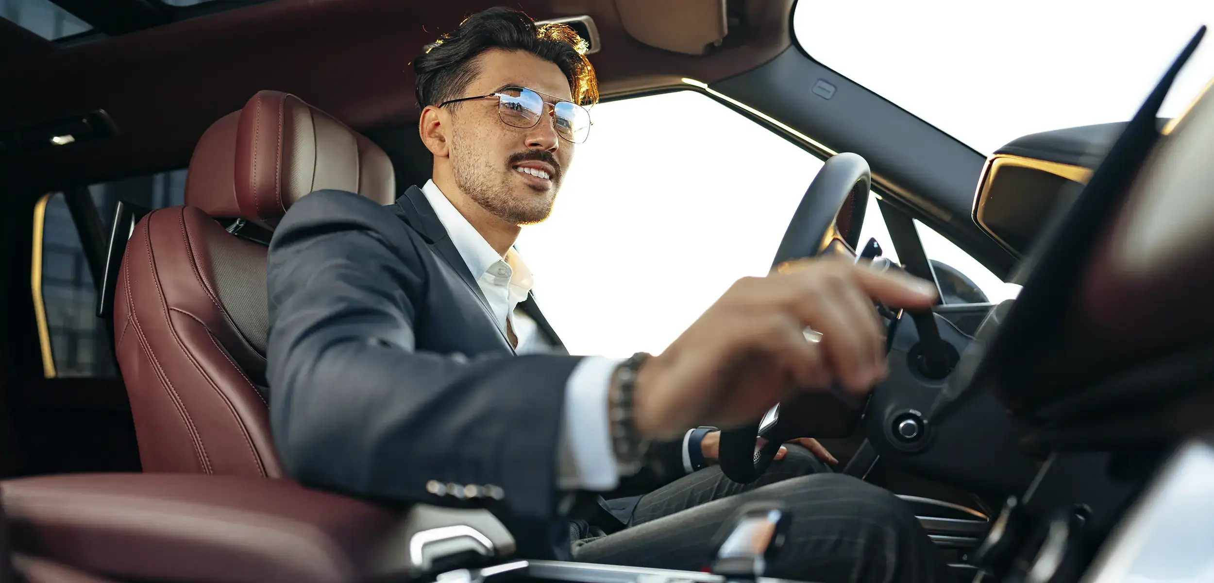 Chauffeur VTC en tenue professionnelle conduisant un véhicule haut de gamme